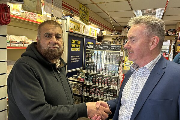 Picture of Donal shaking hands with Abid in his shop in Todmorden
